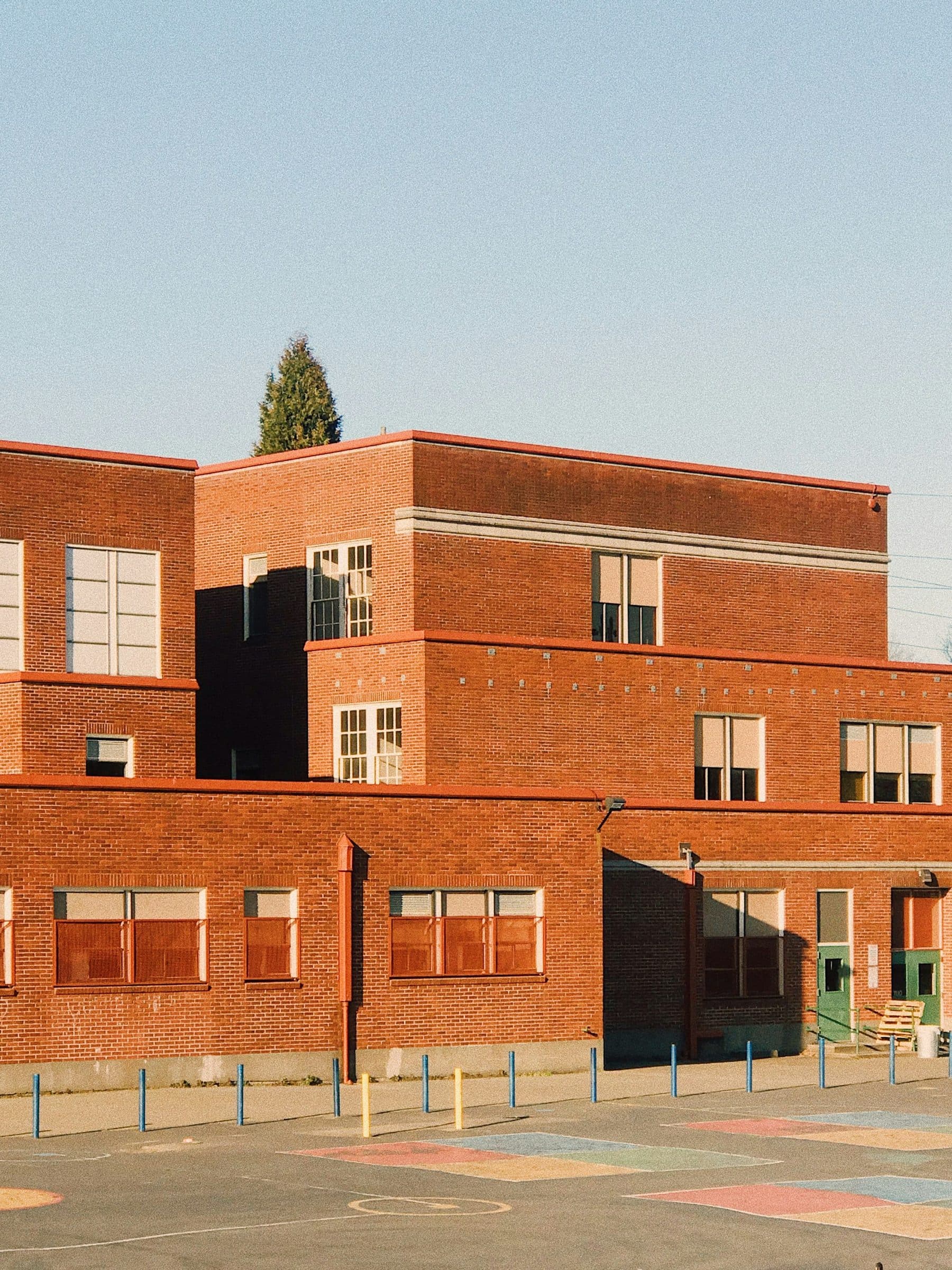 Red-brick school building against a clear sky