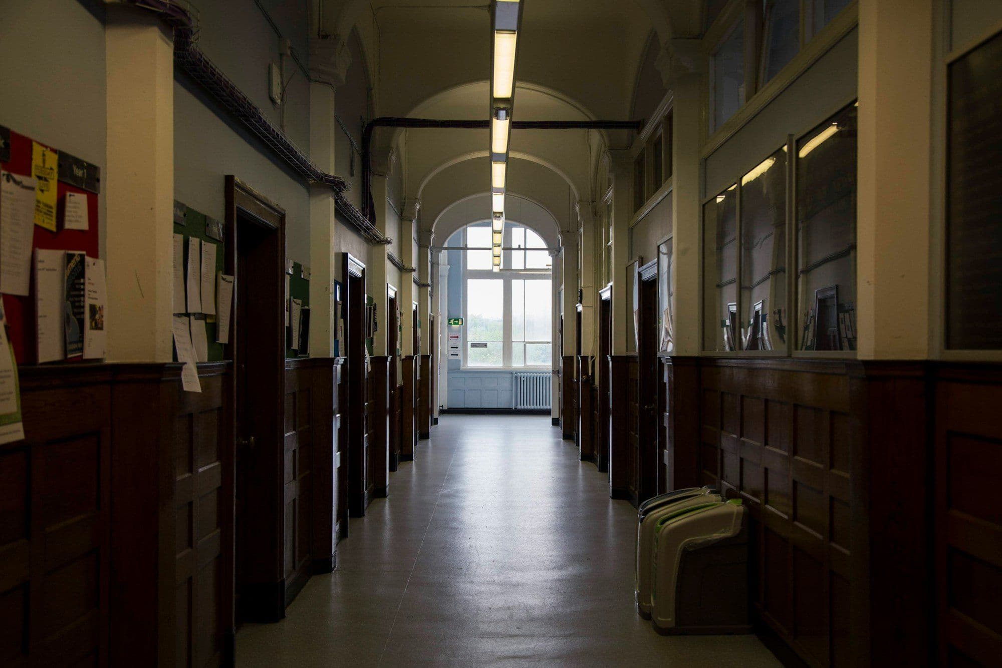 Long school corridor with timber panelling and an arched ceiling