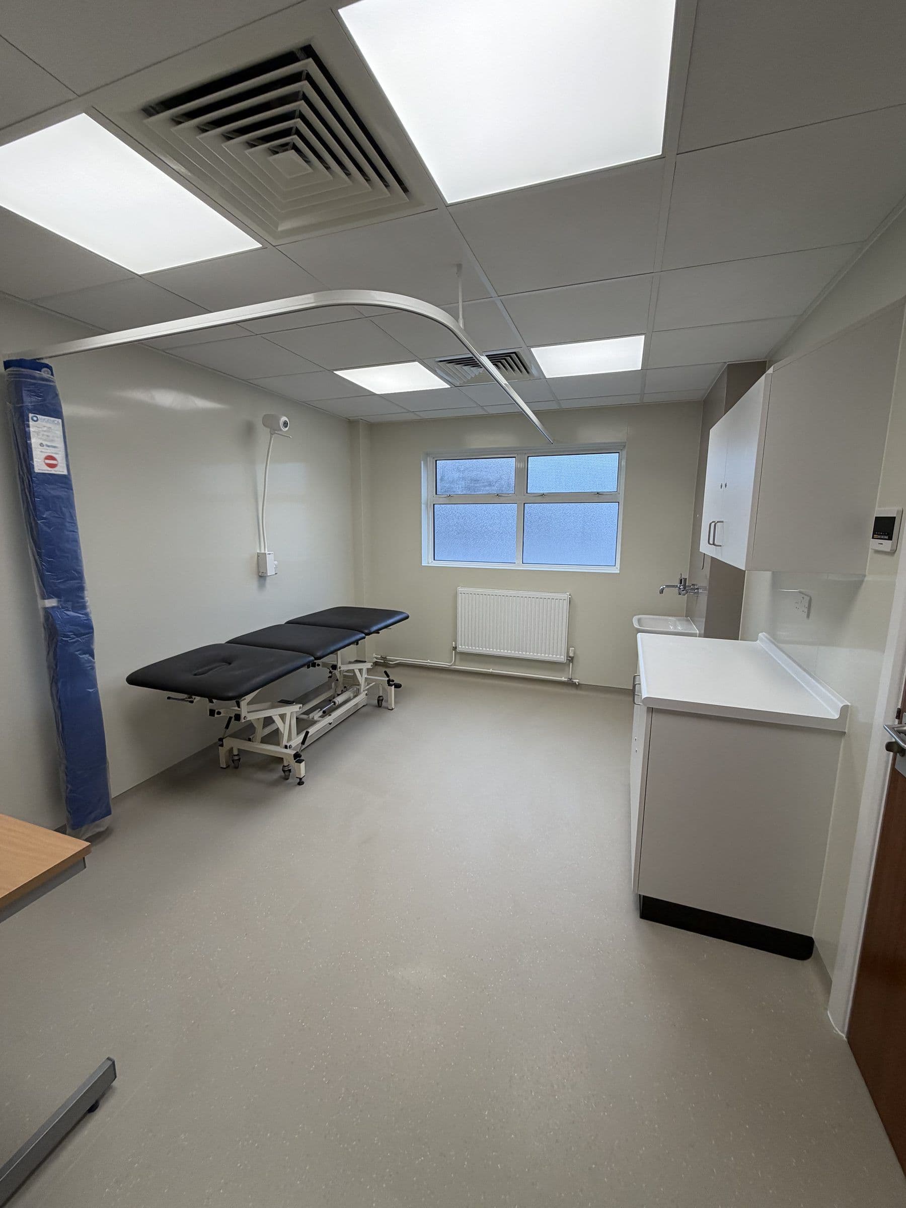 Refurbished clinical room with LED ceiling panels and ventilation grilles