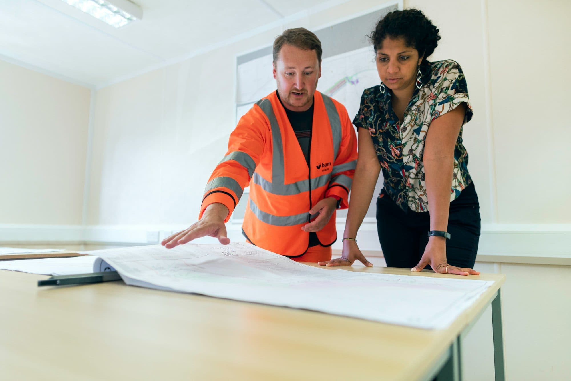 Site manager and client reviewing drawings on a table